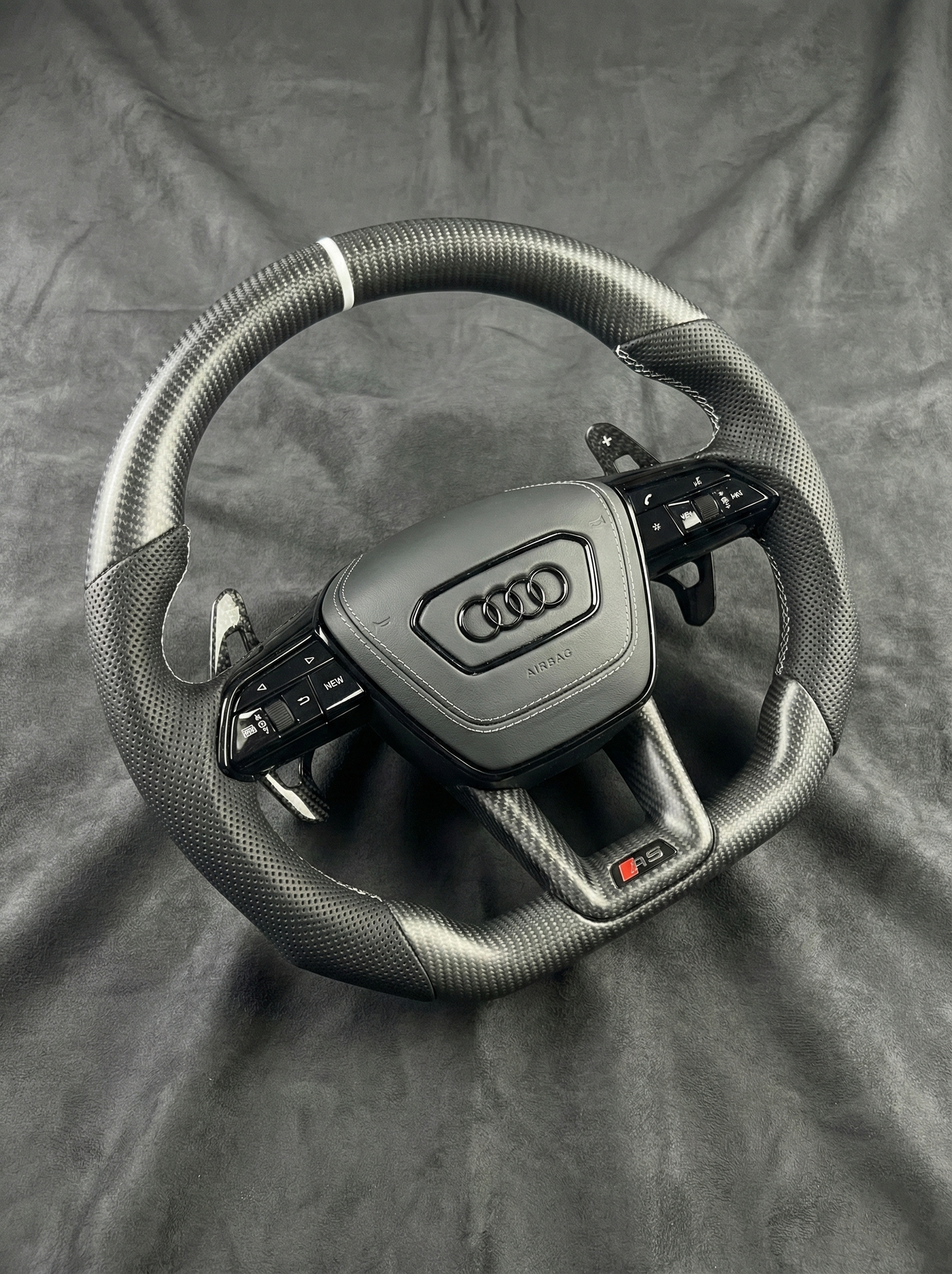 Steering wheel with Audi logo on a gray background