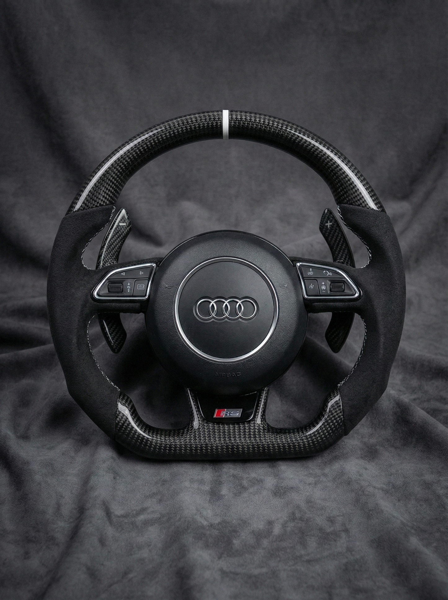 Steering wheel with Audi logo on a dark background