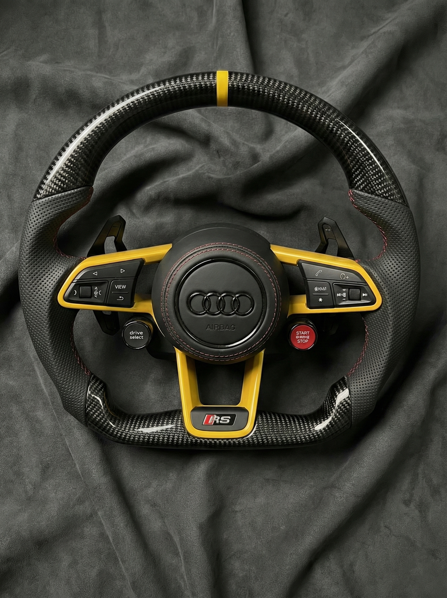 Audi steering wheel with yellow accents on a dark background