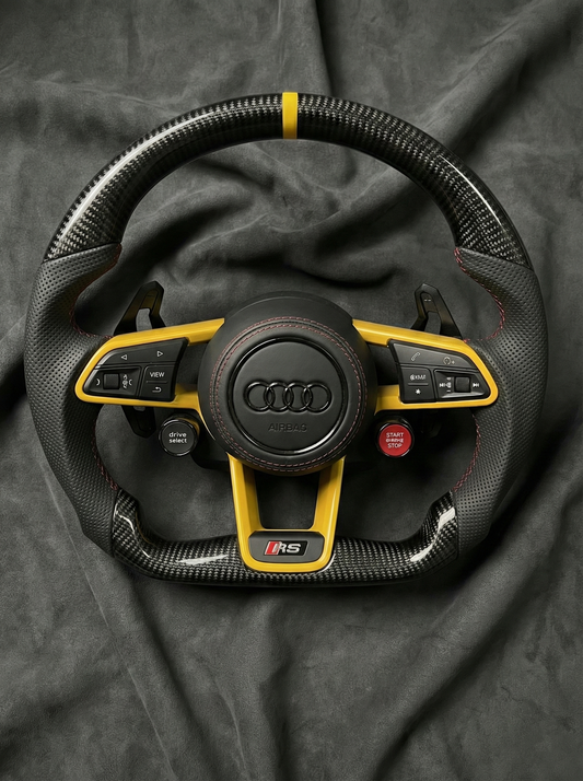 Audi steering wheel with yellow accents on a dark background