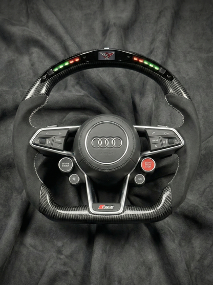 Car steering wheel with Audi logo on a dark fabric background