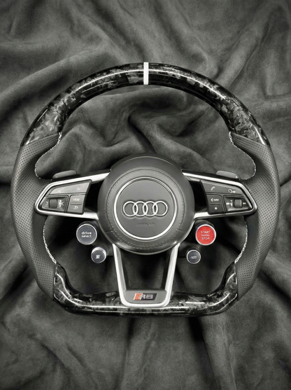 Steering wheel with Audi logo on a textured surface