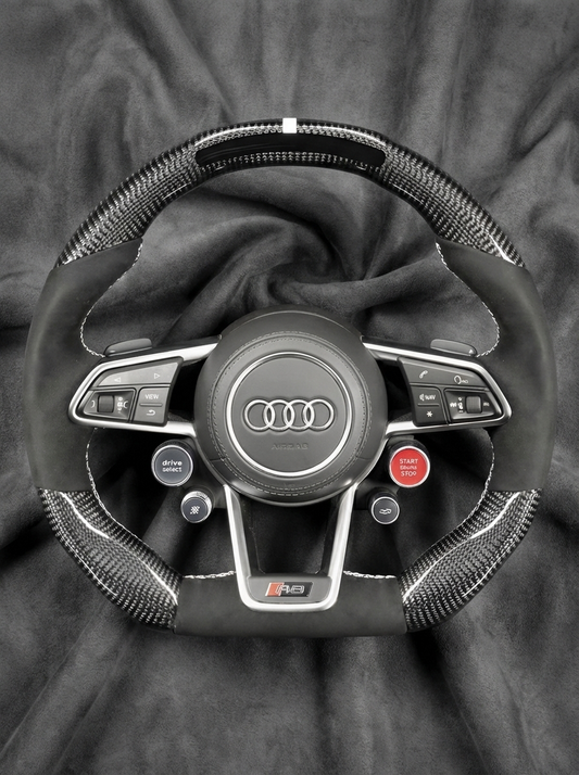 Steering wheel with Audi logo on a dark background