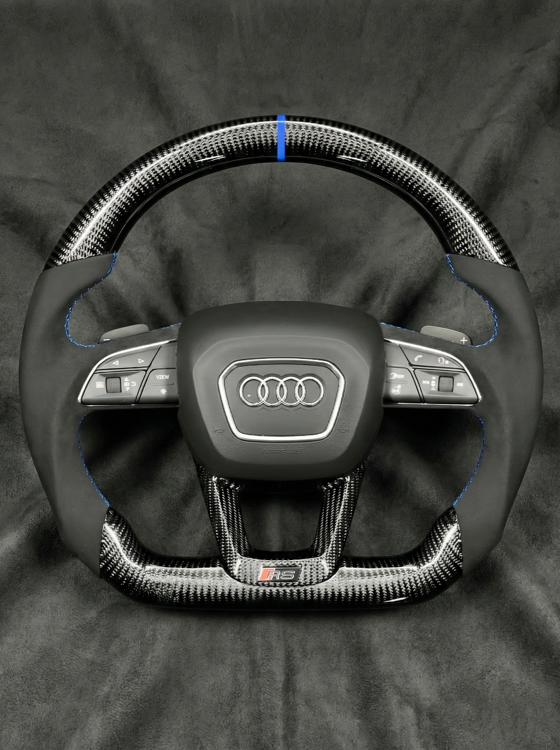 Steering wheel with Audi logo on a dark background