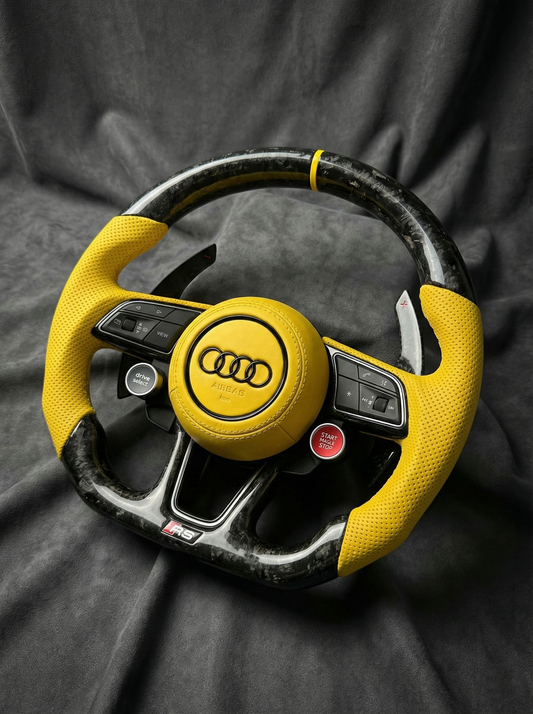 Yellow Audi steering wheel on a dark fabric background