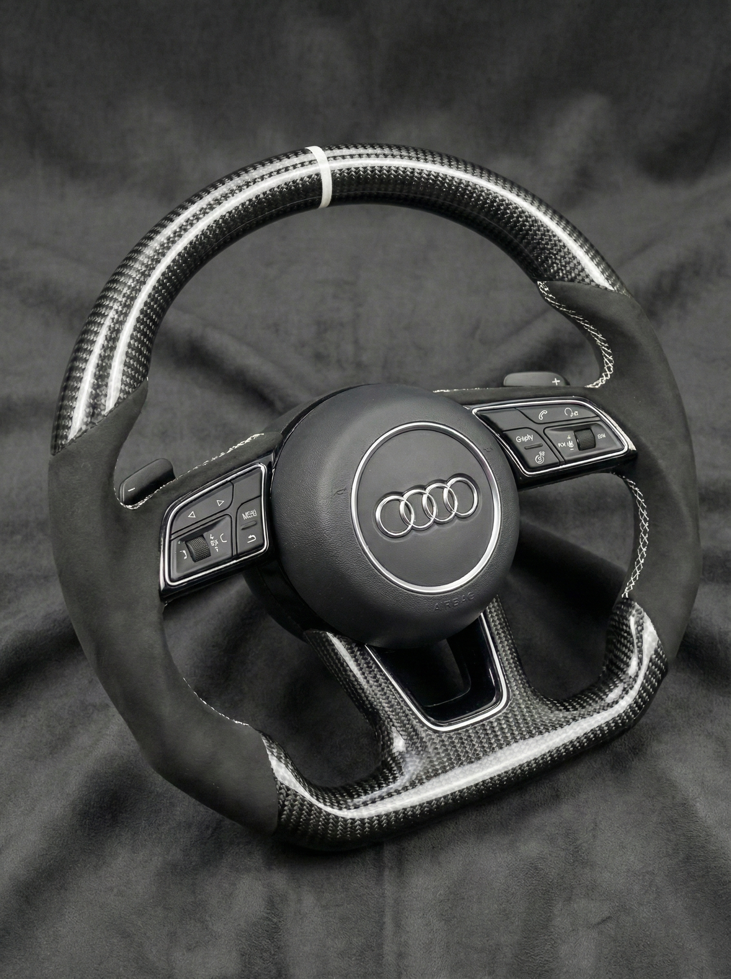 Steering wheel with Audi logo on a dark background