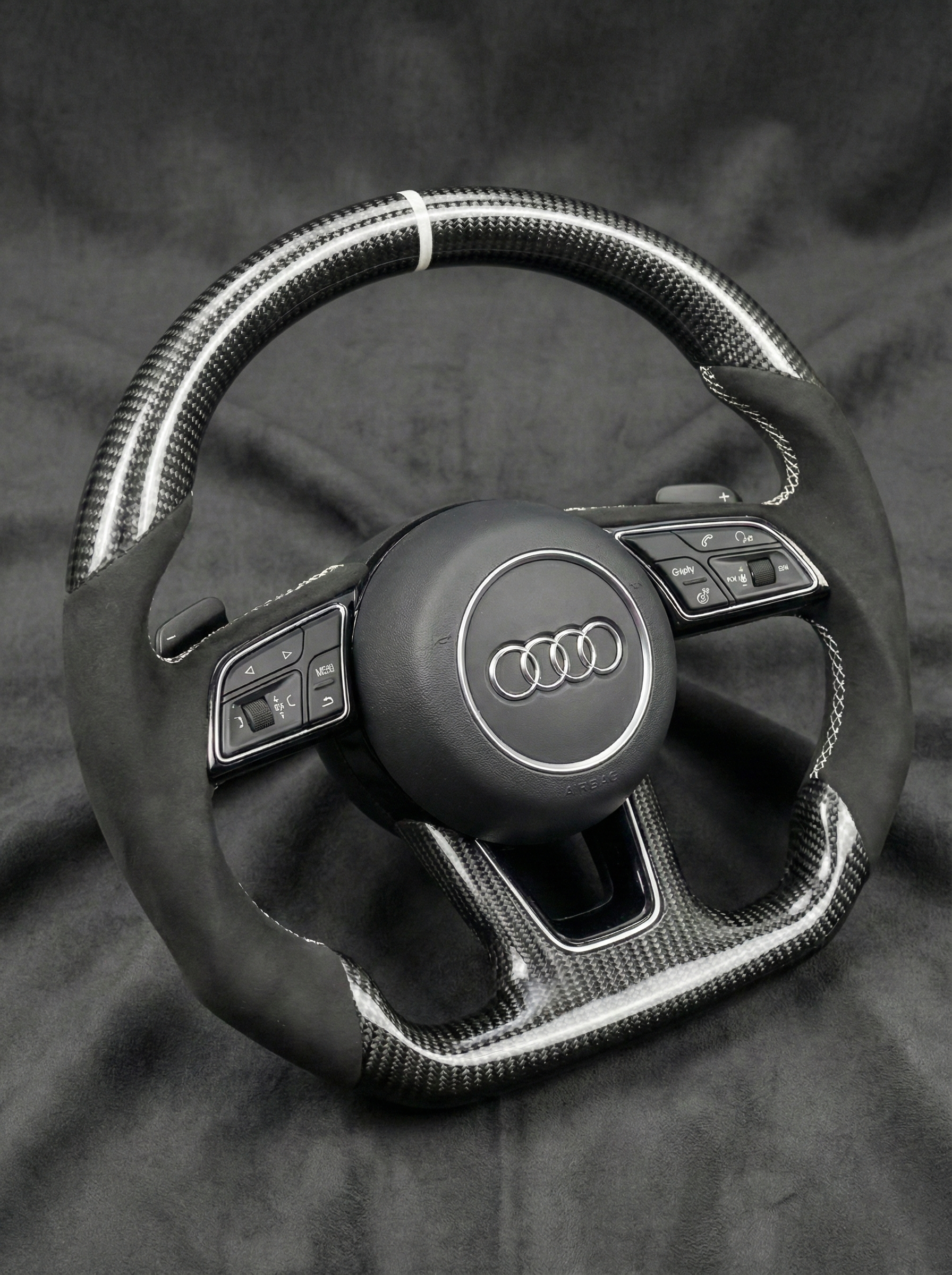 Steering wheel with Audi logo on a dark background