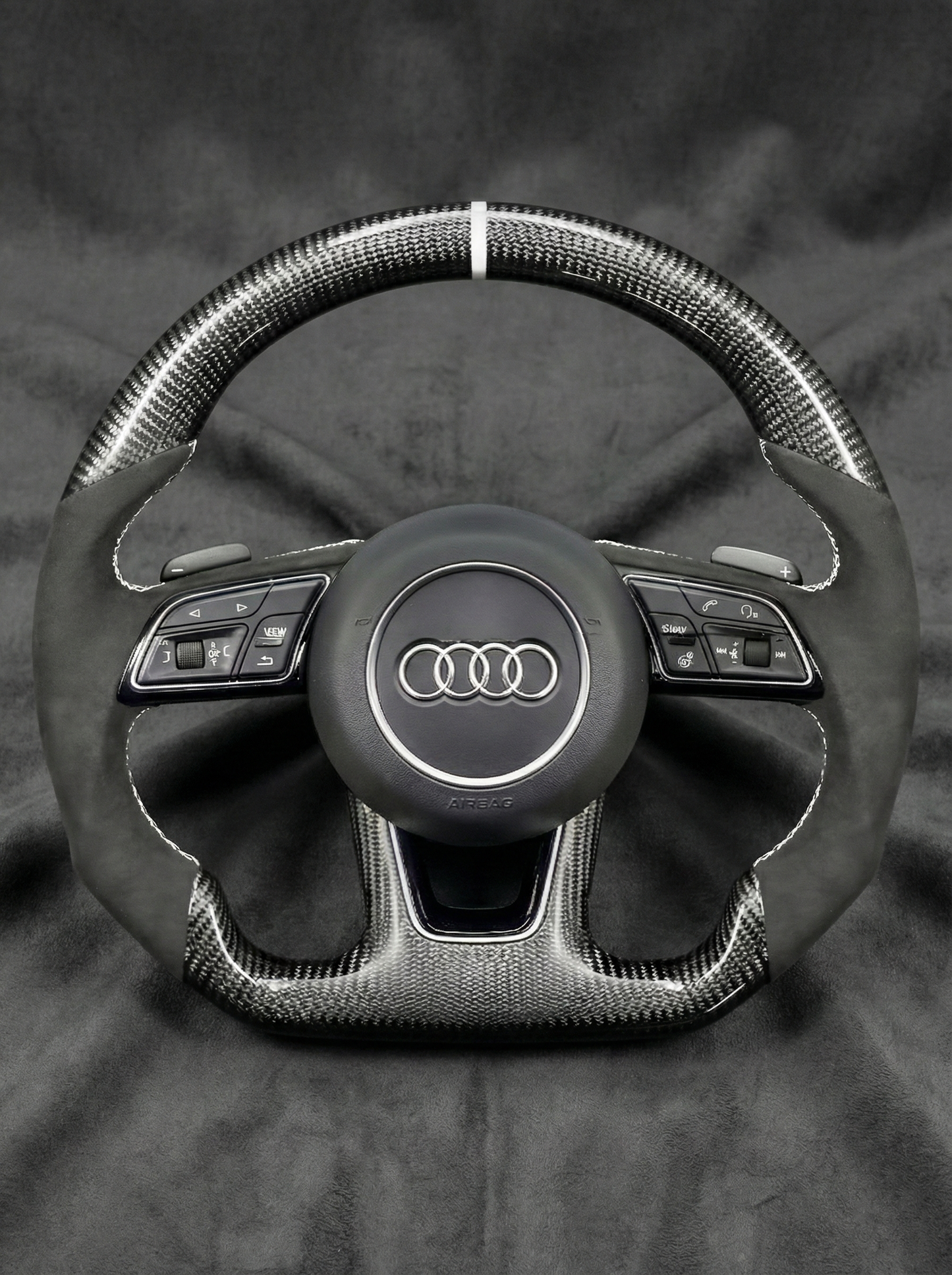 Steering wheel with Audi logo on a dark background