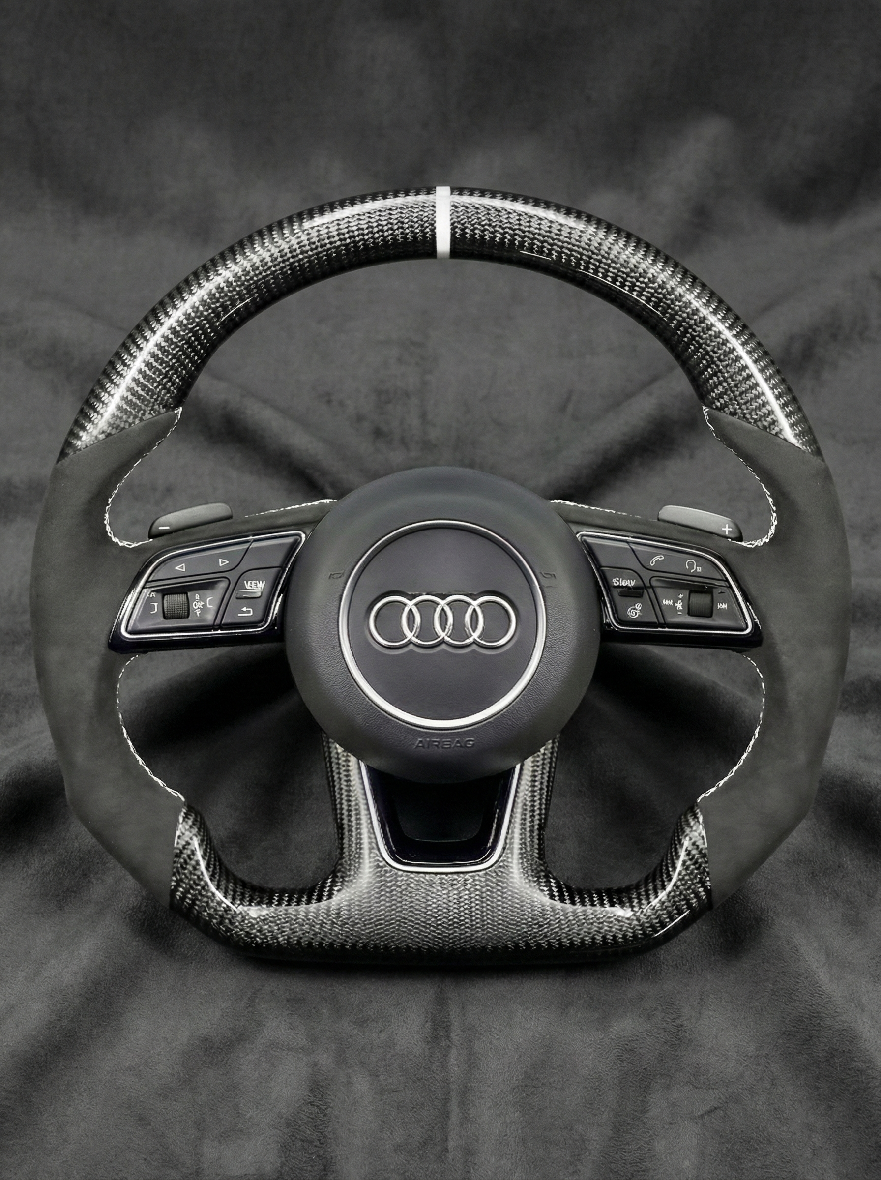 Steering wheel with Audi logo on a dark background
