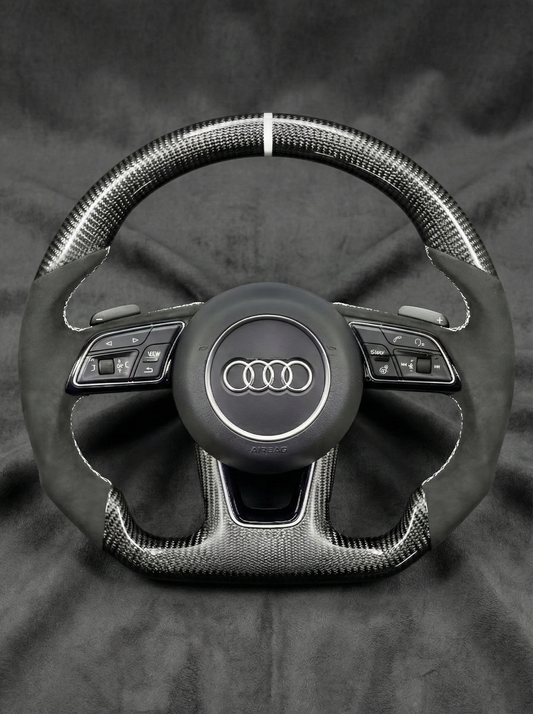 Steering wheel with Audi logo on a dark background