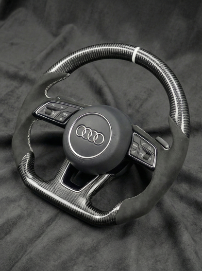 Steering wheel with Audi logo on a dark background