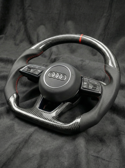 Carbon fiber steering wheel with Audi logo on a dark background