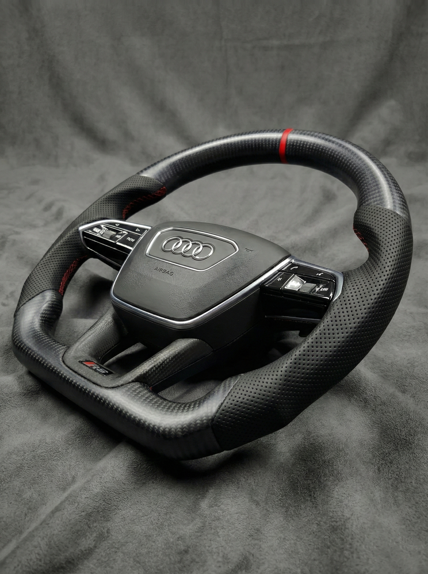 Car steering wheel with Audi logo on a gray background