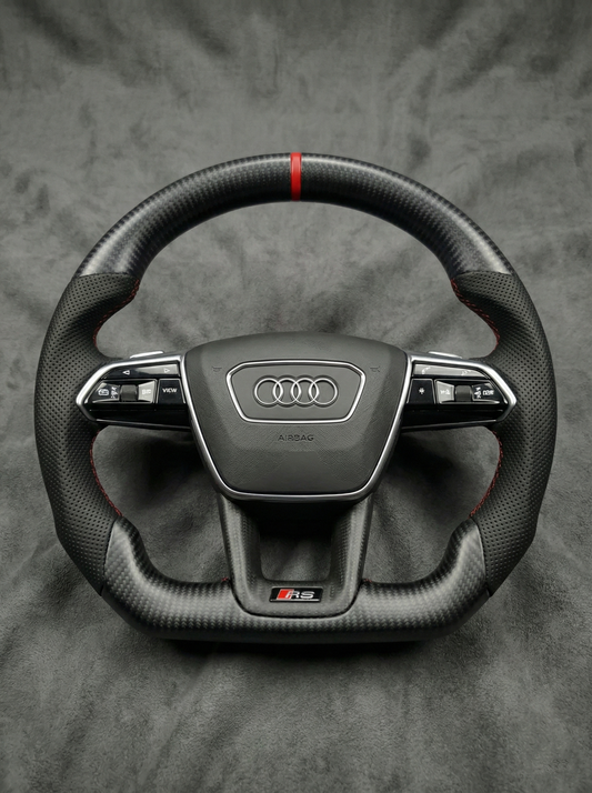 Carbon fiber steering wheel with Audi logo on a gray background