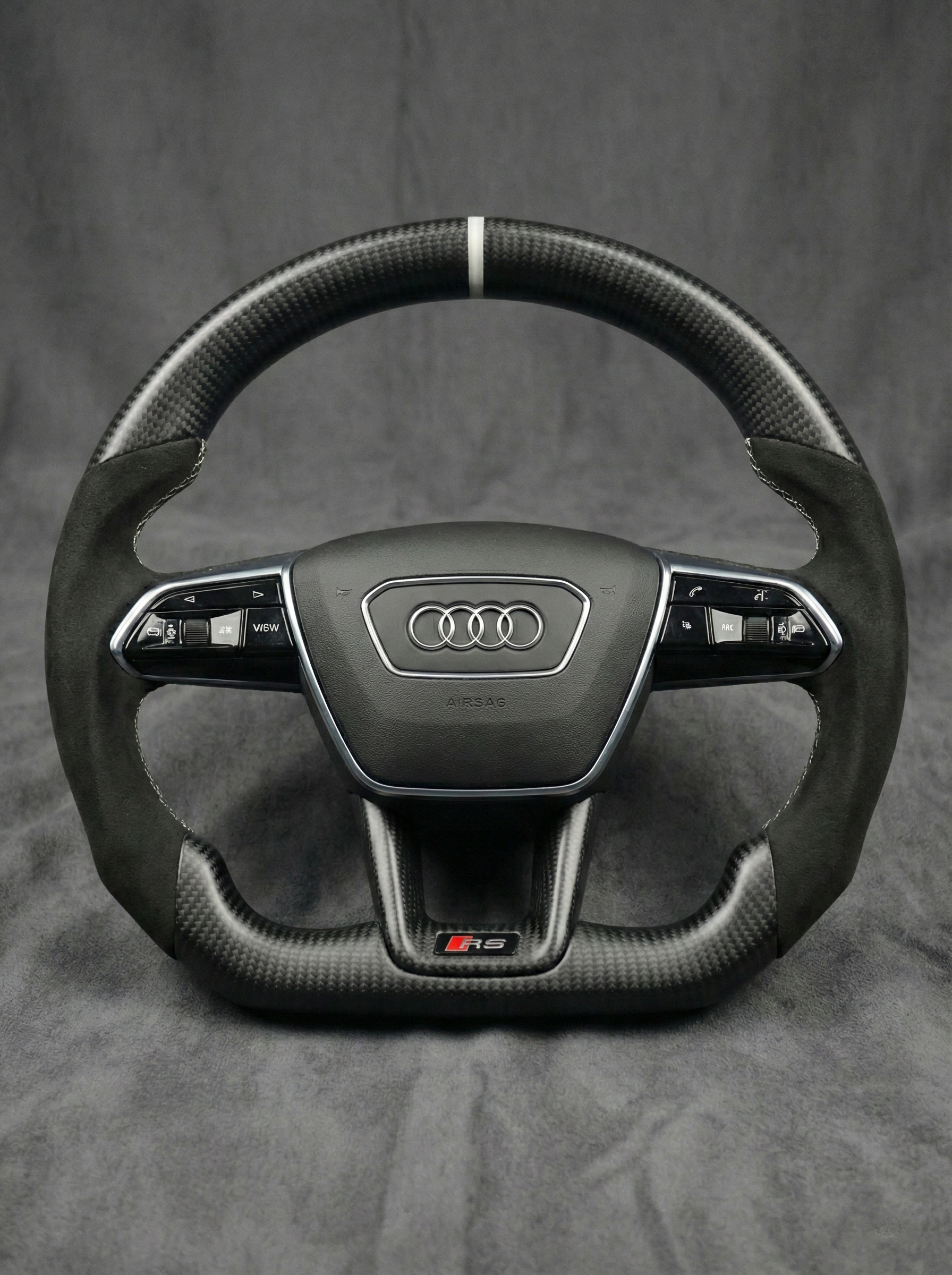 Carbon fiber steering wheel with Audi logo on a gray background