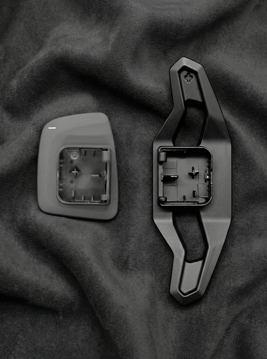 Two car door handles on a dark fabric background